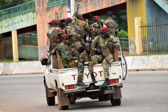 Des membres des Forces armées guinéennes traversent le quartier central de Kaloum à Conakry, le 5 septembre 2021, après que des coups de feu aient été entendus.