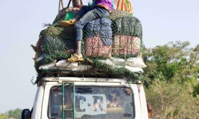 Une camionnette avec ses marchandises et son passager sur le toit, sur la N6 entre Kankan et la frontière malienne.